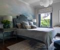 A dreamy bedroom’s Anewall Blue & Grey Cloud wallpaper floats right into a custom Ainsworth bed from Anthropologie. Converted antique trays become a unique bedside table.