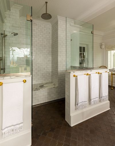 One of the home’s most stunning transformations was turning the large sleeping porch into an expansive primary bath. The shower enclosure wrapped in Timberline 3x6 tile, brick set in “Snow” from Tempest Tileworks gleams beneath an Axor Raindance showerhead.