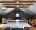 An expanded play area replete with ping pong table features a vaulted ceiling that exposes the collar ties for further panache as well as two sofas to sprawl on.