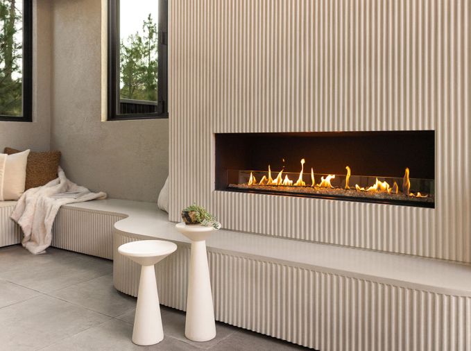 The revamped entertaining area is full of details, including a custom fluted concrete fireplace and curved seating area, a focal point of the space.