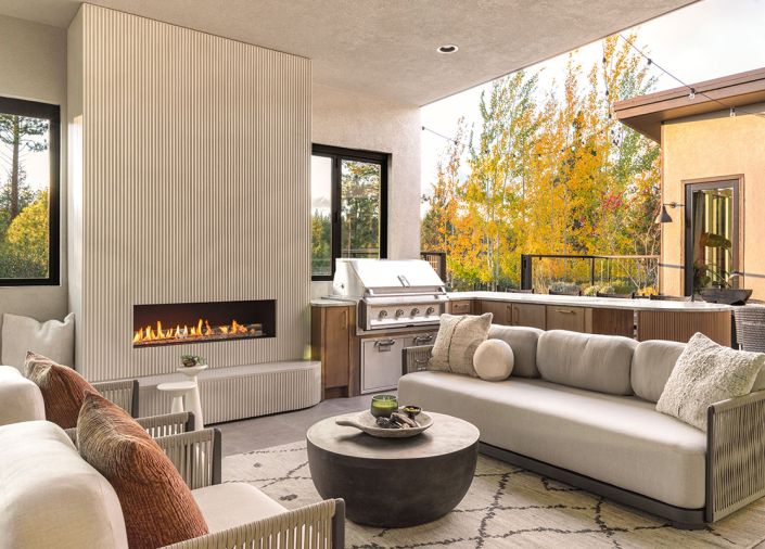 The Persian hand knotted rug and outdoor furnishings are from Area Rug Connection. A Hestan barbecue is tucked into NatureKast cabinetry, refined with a custom plinth and curved edge to mirror the fireplace.