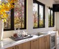 To simplify hosting, Hurst opted for a built-in under-counter refrigerator, sleek counters and thoughtfully placed outdoor lighting. Abundant windows let in additional natural light.