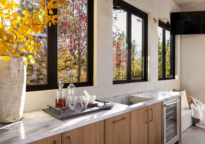 To simplify hosting, Hurst opted for a built-in under-counter refrigerator, sleek counters and thoughtfully placed outdoor lighting. Abundant windows let in additional natural light.