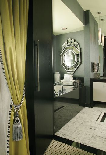 Chartreuse satin drapery with zebra stripe trim leads to the primary bath, with an elegant polished black granite tub surround. Blanco Venatino marble flooring with Walker Zanger&rsquo;s Tribeca check inlays.