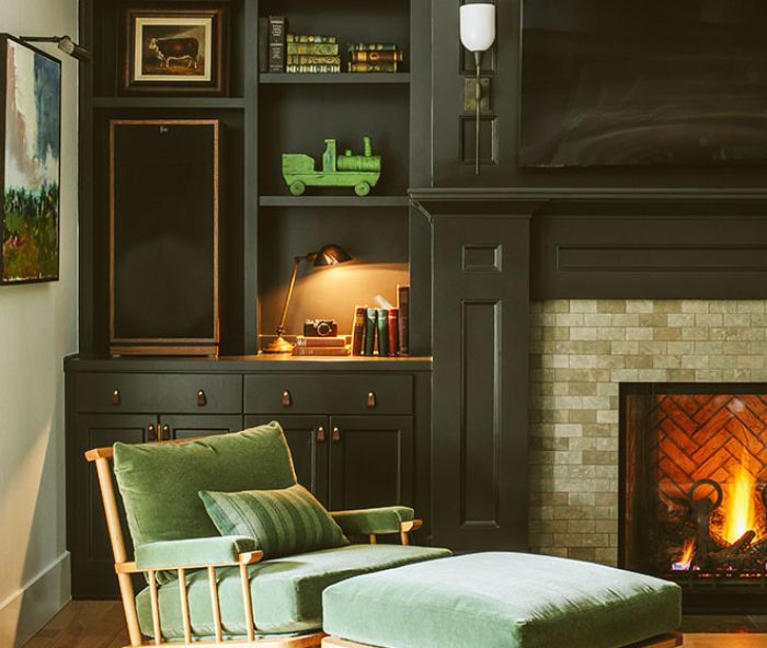 Humphrey obscures the television by painting the adjacent cabinetry in Benjamin Moore &ldquo;Cheating Heart&rdquo;. Mohair cushions on Nickey Kehoe chair play off colors in the rug.