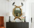 An eclectic combination of unique finds creates a showstopping entry. Set against a tongue and groove coffered ceiling, a black Lawson-Fenning chandelier teams with a geometric Sabin sideboard. A &ldquo;had-to-have&rdquo; Grisaille side chair counters the 22-carat shellacked tree mirror.