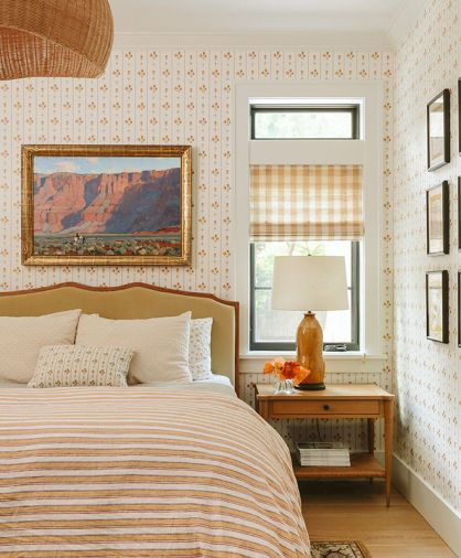 The bedframe by Nickey Kehoe echoes the tone of the floral stripe wallpaper designed by Max Humphrey with Chasing Paper. Gingham window covering and a duvet by Schoolhouse complement the look.