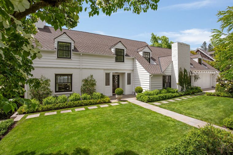 Set back from the road, a grassy area allows breathing space. Handsome black Marvin windows and doors throughout from Portland Millwork pop against the exterior and architectural composite roofing.