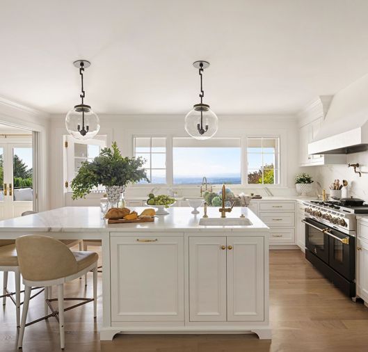 The newly designed family-centric kitchen is filled with appliances sourced from Eastbank Contractor Appliances, Waterworks plumbing fixtures, cabinetry from Eddie Murphy, and crisp Calacatta counters and backsplash.