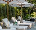 The chic outdoor space has room for lounging and conversation with a series of Kingsley Bate lounges, umbrellas, and ceramic side tables.