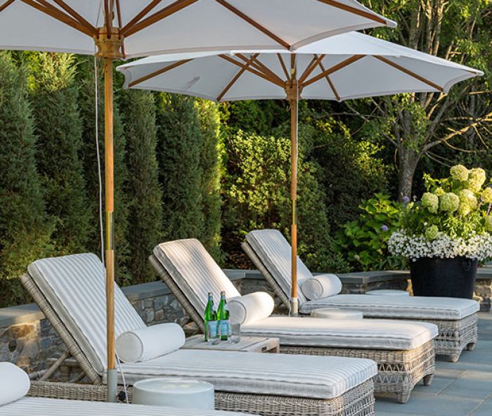 The chic outdoor space has room for lounging and conversation with a series of Kingsley Bate lounges, umbrellas, and ceramic side tables.