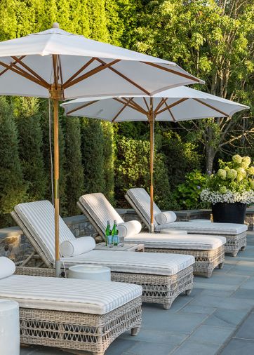 The chic outdoor space has room for lounging and conversation with a series of Kingsley Bate lounges, umbrellas, and ceramic side tables.