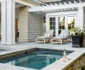 Tucked behind the house, the integrated hot tub is a family favorite. Finished in durable Pennsylvania Bluestone for the seating surround and complemented by Ocean Pearl stone siding, the materials create a seamless continuity with other areas of the backyard.