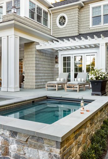 Tucked behind the house, the integrated hot tub is a family favorite. Finished in durable Pennsylvania Bluestone for the seating surround and complemented by Ocean Pearl stone siding, the materials create a seamless continuity with other areas of the backyard.