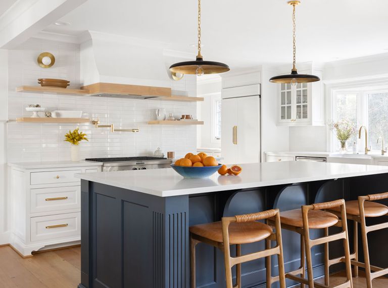 Instead of a crisp white, a soft, slightly warm hue, Benjamin Moore&rsquo;s &ldquo;Swiss Coffee&rdquo;, sets a neutral stage for Rejuvenation hardware and an island bathed in &ldquo;Stonecutter&rdquo;, a saturated teal.