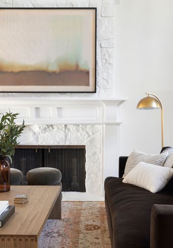 While the living room is grounded with brown velvet sofas from Perch Furniture and an earth-toned rug, the abstract work from artist Roseanne Kenny showcases the full palette above the gas fireplace and brass reading light.