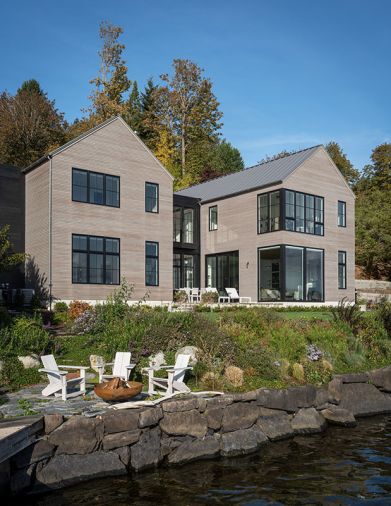 The exterior is covered in stained cedar siding, and combined with a standing seam metal roof. The Loewen windows and doors, from Windows, Doors & More, capture the stunning water views. Multiple lounge spots, on the shore and closer to the house, facilitate indoor-outdoor flow.