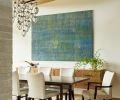 The dining room hosts a custom table across from Howardena Pindell artwork. The blown glass chandelier by Holly Hunt and Alison Berger Glassworks replicates the look of blooms on a branch.