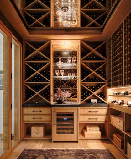 In the welcoming wine room, all the rift-cut white oak storage is by Northwest Custom Interiors, with Tanner&rsquo;s Craft leather and bronze hardware, and an antiqued mirror backsplash.