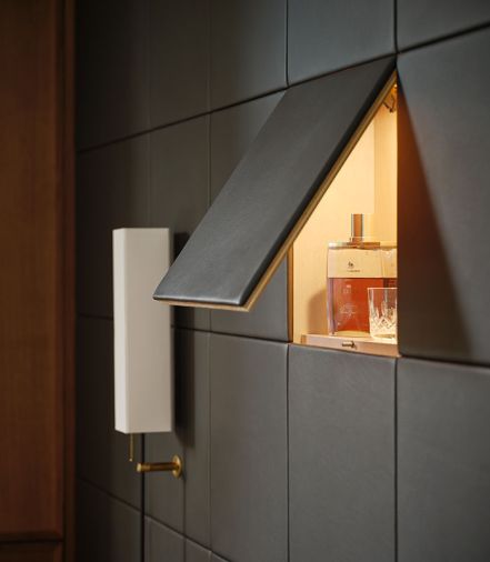 A bar surprises behind a custom EcoDomo leather panel.