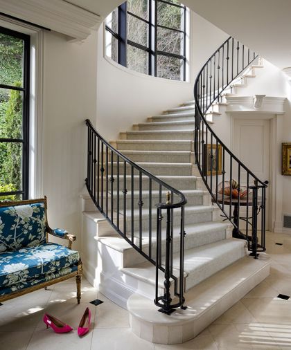 In the foyer, a soft runner bedecks the stairway, while existing creamy marble, with marble insets, lines the floor.
