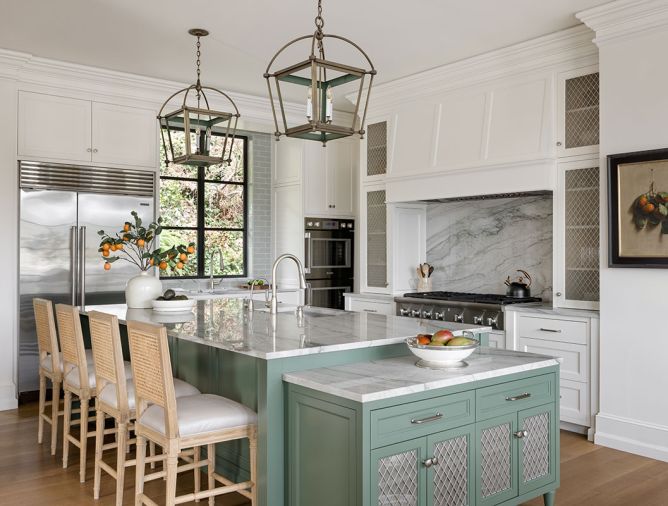 In the kitchen, the island is painted in &ldquo;Holiday Wreath 447' from Benjamin Moore, with the Urban Electric Co lights above it painted to match. The Statuario Quartzite counters and backsplash are from Architectural Surfaces.