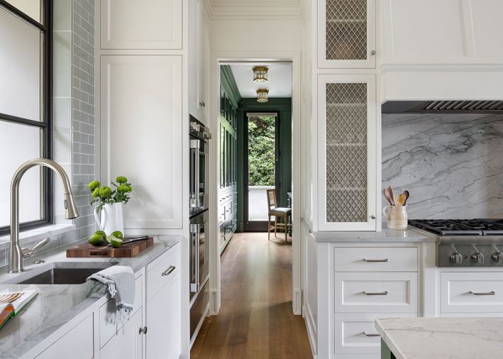 The cabinets feature small diamond grille in polished nickel from Katonah Architectural Hardware, while the walls have Country Equipe &ldquo;Mist Green Gloss&rdquo;&rsquo; tile from United Tile.