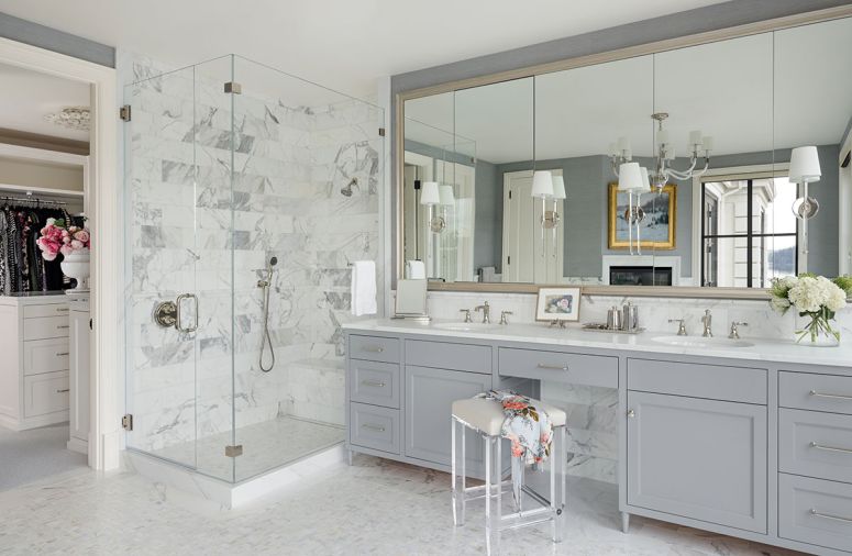 In the primary bathroom, custom cabinetry is covered in Benjamin Moore&rsquo;s &ldquo;Timber Wolf&rdquo; hue, dressed with Waterstreet Brass hardware, and topped with Calacatta Gold Aspen counters.