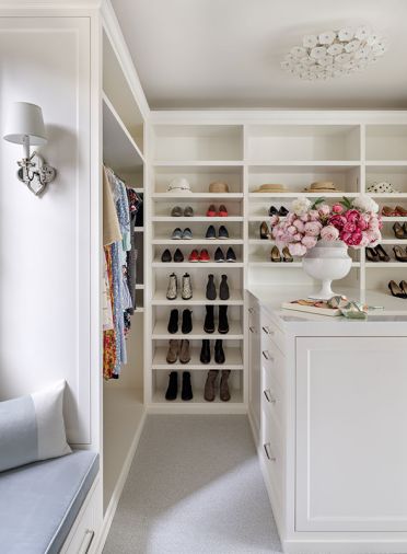 The dressing room features custom cabinetry by Warmington & North that include tray inserts for jewelry, a Rainier Quartz counter and Stark Carpets floor covering. The cozy window seat was reupholstered in Pindler fabric by La Fabrique.