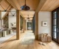 The project team brought in a medley of woods to anchor the main room, from the timber trusses to the white oak flooring found throughout, which is from Montello Design .The pendant lights are from CB2 and lining the walkway is a soft neutral runner underfoot.