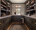 The custom cabinetry in the &ldquo;workhorse&rdquo; of a dry pantry was fabricated by Crystal Cabinets, who did the cabinetry throughout. The cabinetry is painted in Sherwin Williams &ldquo;Muddled Basil&rdquo; with brass Armac Hardware from Chown Hardware. The rug is from Andonian Rugs, while the sconces were found at Lostine.