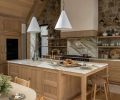Custom floating shelves, crafted by Artisan Inc., flank the Lacanche range, adding both function and warmth to the space. Conical pendants from The Lamp Workshop hang above the island and sink, illuminating the exquisite House of Rohl plumbing fixtures.