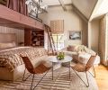 In the &ldquo;Summer Room,&rdquo; Artisan Inc. installed custom bunks using cabinetry by Crystal Cabinets, painted in Sherwin Williams &ldquo;Velvety Chestnut.&rdquo; The walls are painted in Benjamin Moore &ldquo;Ballet White,&rdquo; as a backdrop for the textural Lee Industries sofa from J Garner Home.