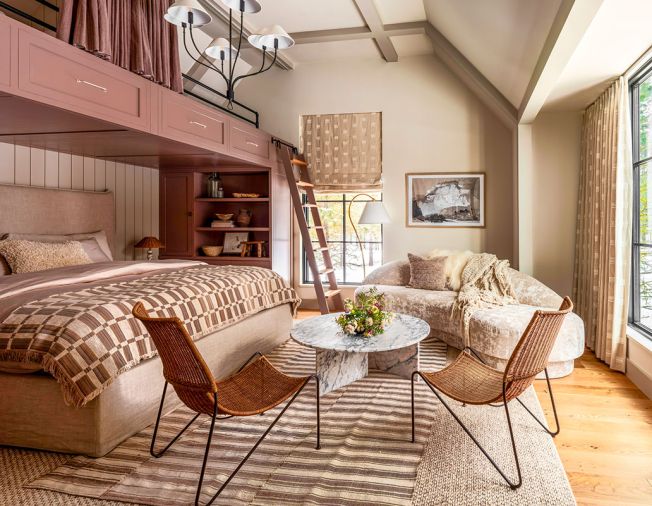 In the &ldquo;Summer Room,&rdquo; Artisan Inc. installed custom bunks using cabinetry by Crystal Cabinets, painted in Sherwin Williams &ldquo;Velvety Chestnut.&rdquo; The walls are painted in Benjamin Moore &ldquo;Ballet White,&rdquo; as a backdrop for the textural Lee Industries sofa from J Garner Home.