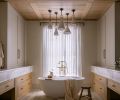 The custom ceiling is composed of waxed white oak tongue and groove and shallow box beams. Handmade clay pendants by Natalie Page Studio hang above the cement soaking tub and House of Rohl tub filler.