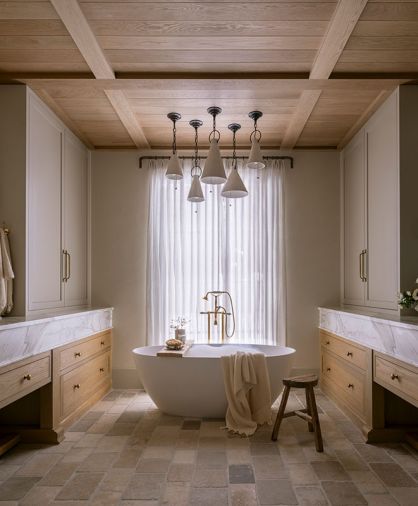 The custom ceiling is composed of waxed white oak tongue and groove and shallow box beams. Handmade clay pendants by Natalie Page Studio hang above the cement soaking tub and House of Rohl tub filler.
