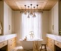 The custom ceiling is composed of waxed white oak tongue and groove and shallow box beams. Handmade clay pendants by Natalie Page Studio hang above the cement soaking tub and House of Rohl tub filler.