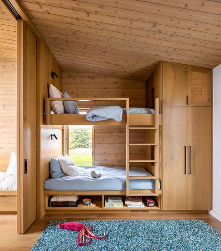 The built-in bunk beds are fashioned from the same white oak as the kitchen, with Enna Square wall sconces from Astro Lighting, Munich Collection hardware, and linens from Ventidora.