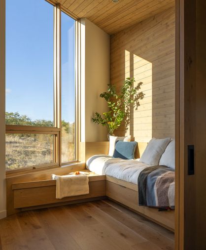 The corner window seat and reading nook, in the kids&rsquo; domain, is backed by Western red cedar and is cozied with a blanket from Pendleton Woolen Mills.