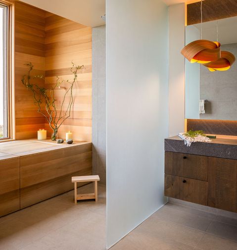 The floating vanity has stained white oak cabinetry and a Basaltina counter, with &ldquo;Bateig Blue&rdquo; tile from Ann Sacks on the floor.