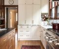 The custom cabinetry is painted in Sherwin Williams &ldquo;Steamed Milk&rdquo; and adorned with unlacquered brass hardware from Rejuvenation. The heart of the kitchen is a soapstone countered island featuring the same brass touchpoints.