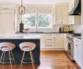 Elegant cabinetry enrobes JennAir appliances, a Delta faucet, and an Elkay sink, all sourced from Ferguson. Daltile Calacatta gold wall tile sparkles, popping against island cabinetry painted in Benjamin Moore&rsquo;s &ldquo;Black Jack.&rdquo;