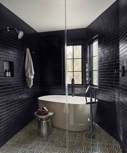Grounding the wet shower and bath is eye catching Mulholland Noir Blend Ann Sacks tile. K711 black matte tile from Rittenhouse enrobes a Signature Hardware Ocala tub with Hansgrohe Tecturis plumbing fixtures.