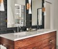 Utopia Double Sconces add 1930s glitz to his and hers oversized vanity mirrors. The pair of Kohler Verticyl undermount sinks are set in Calacatta Gold Quartz countertops.