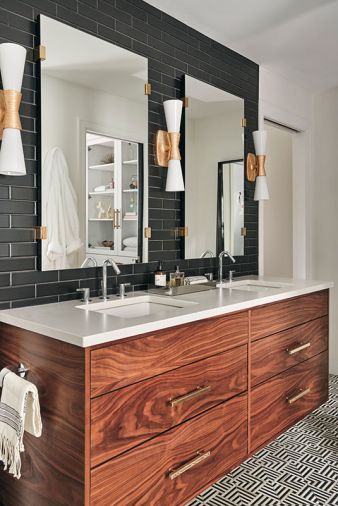 Utopia Double Sconces add 1930s glitz to his and hers oversized vanity mirrors. The pair of Kohler Verticyl undermount sinks are set in Calacatta Gold Quartz countertops.