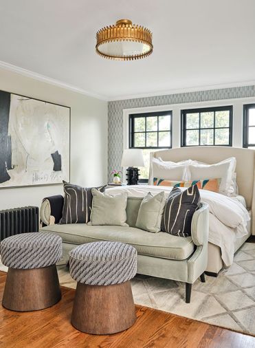The owners are wrapped in a warm embrace from black radiator to new windows to the &ldquo;Untitled #15' Soicher-Marin artwork and Fabricut fabric upholstered ottomans. The Leslie fixture by Visual Comfort crowns the primary bedroom.