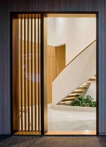 Homeowners chose the custom stone mix for the Venetian Terrazzo Co. floors throughout. A mid-century style indoor planter grounds and softens the sensuously curved staircase with custom railing created by MW Design Workshop.