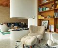 The library and den are cozied by a unique RH Peterson Ceramic Firebrick fireplace from Lisac&rsquo;s Fireplace & Stoves. Sean Croghan artwork sits atop rift sawn oak library shelving and a brick wall extends outward to the home&rsquo;s architectural exterior.