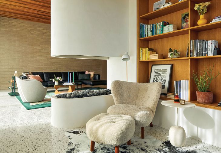 The library and den are cozied by a unique RH Peterson Ceramic Firebrick fireplace from Lisac&rsquo;s Fireplace & Stoves. Sean Croghan artwork sits atop rift sawn oak library shelving and a brick wall extends outward to the home&rsquo;s architectural exterior.