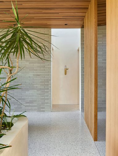 Cement Elegance created the primary bath&rsquo;s concrete counter and integrated Breeze Sink set against plaster walls finished in &ldquo;Cabbage Rose&rdquo; by Sherwin Williams. Robern lighting tops the mirrored cabinets.